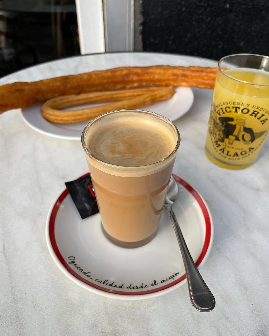 Café con leche y churros sobre mármol